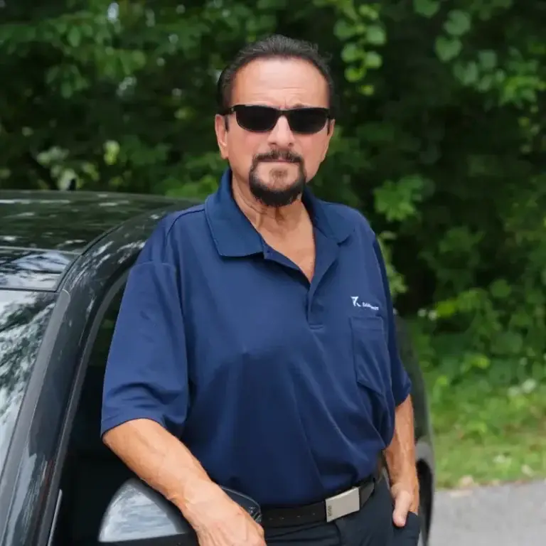 Gennaro, wearing sunglasses and the company uniform, is part of the Niagara courier team at Reliable Deliveries.