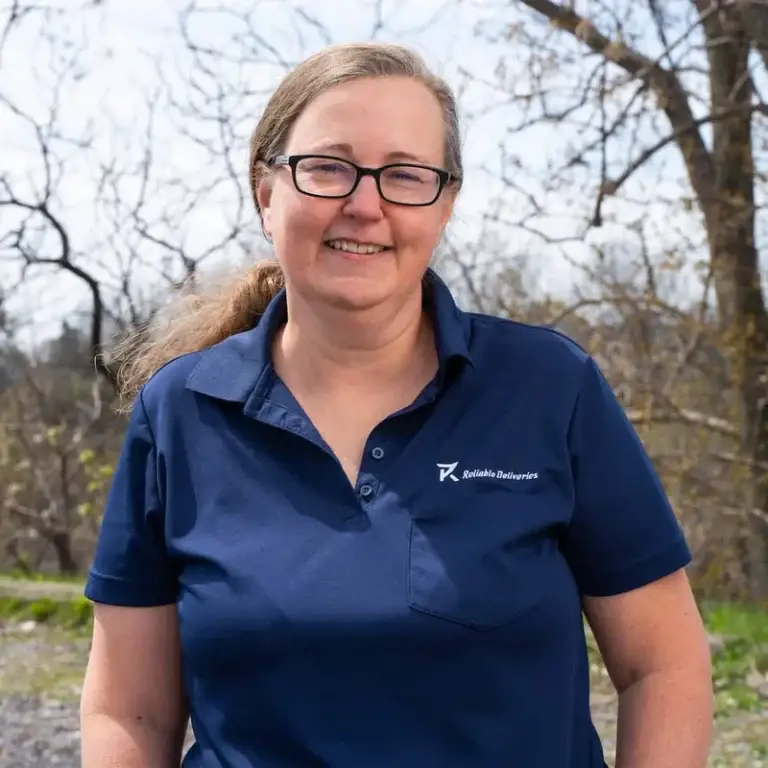 Judy, co-owner of Reliable Deliveries, a Niagara courier company, smiling in the company uniform.
