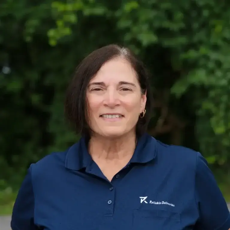 Mary, part of the courier dispatch Niagara relies on at Reliable Deliveries, smiling in the company uniform.