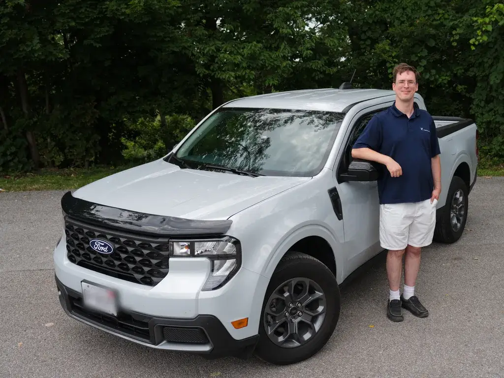 Delivery driver standing beside a white pickup truck, ready for same-day courier Niagara service.