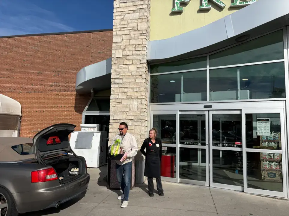 Driver collecting a client’s gift basket at a storefront for Reliable Deliveries, a Niagara courier service